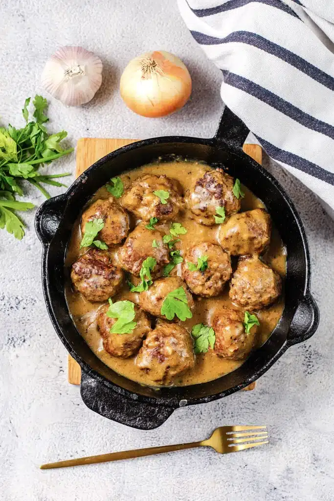 IKEA Swedish meatballs filling a black skillet, photographed from directly above