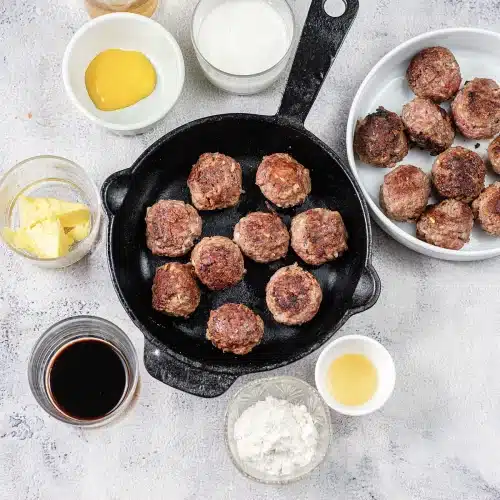 Small browned rounds searing in a black cast iron pan