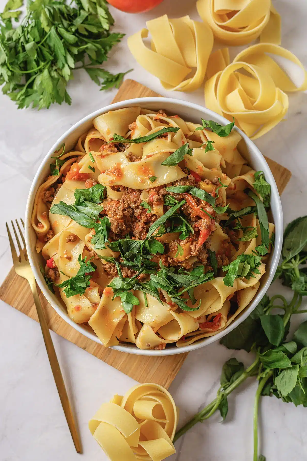 Italian drunken noodles seen close with sausage, peppers and fresh basil
