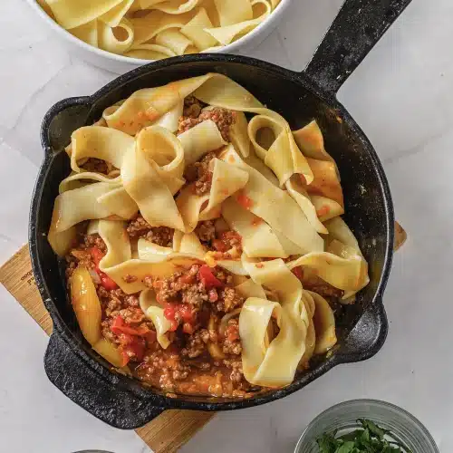 The finished skillet with everything tossed together and herbs alongside