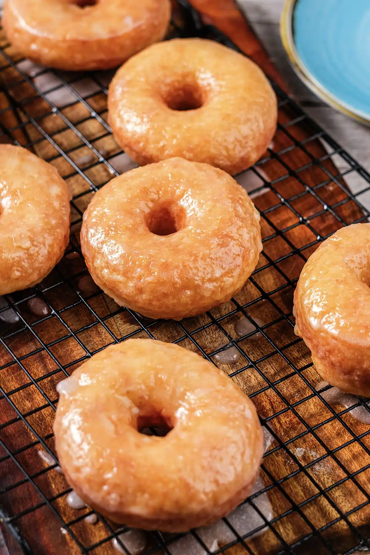 Copycat Krispy Kreme donuts glazed and cooling on a black wire rack