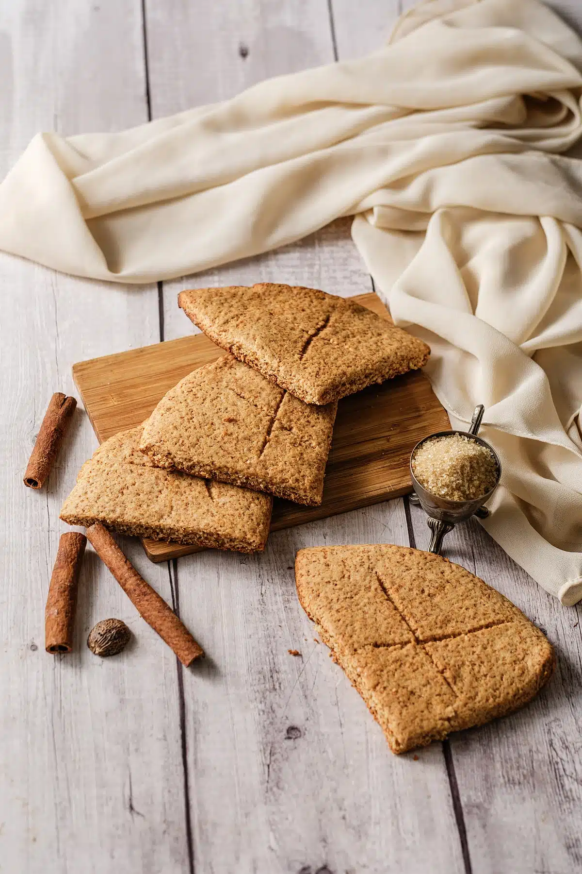 Lembas bread squares on a bamboo board with cinnamon sticks and whole nutmeg