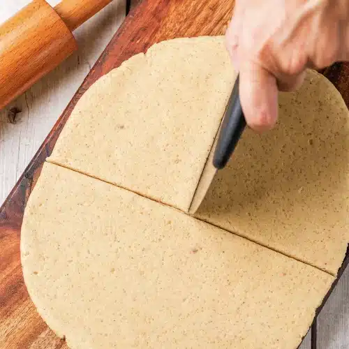 The round being cut cleanly in half with a scraper