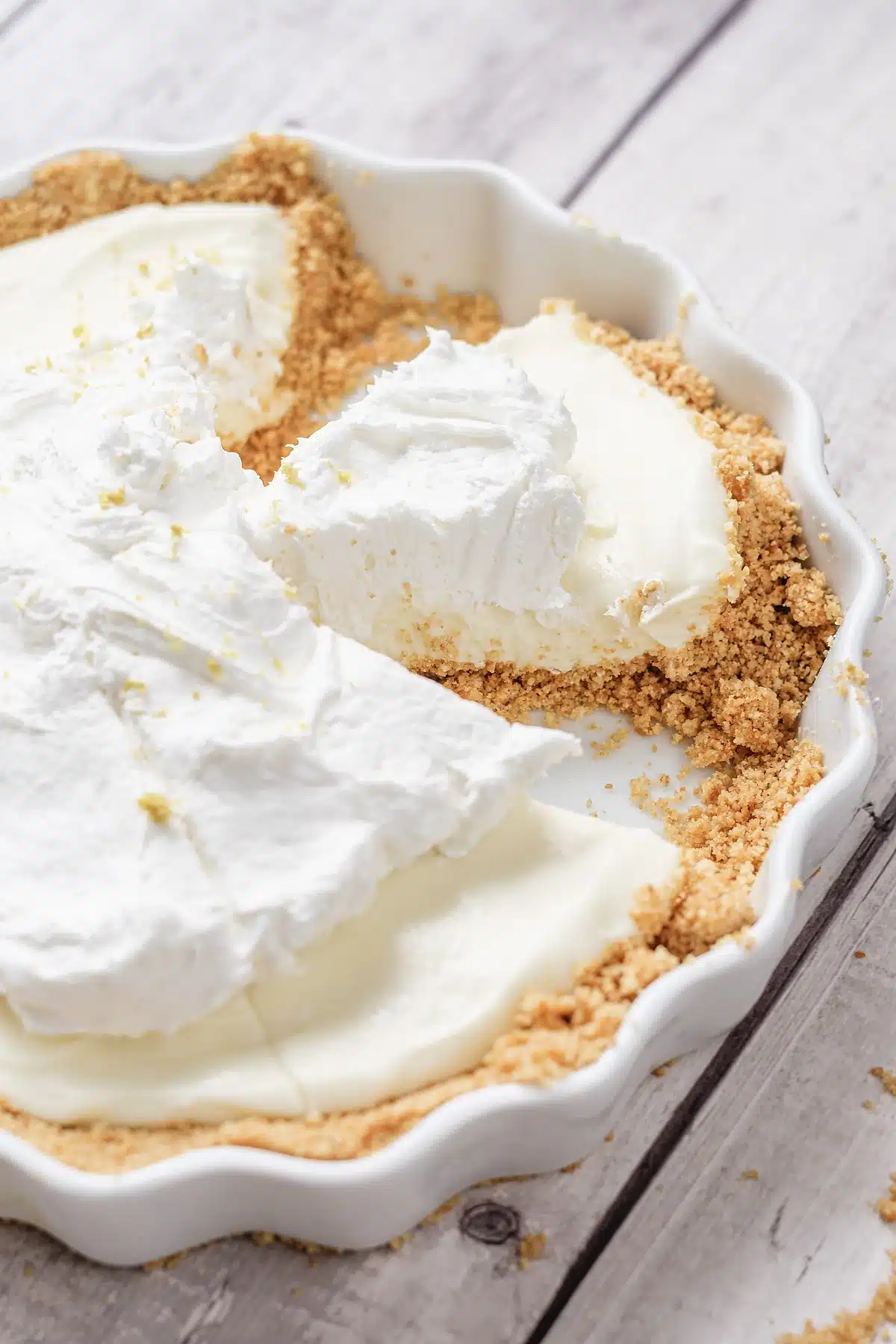 Lemon icebox pie in a fluted dish with one slice cut and lifted