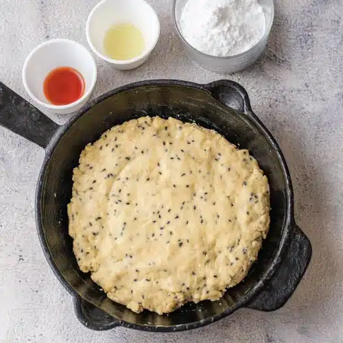 Scone dough pressed into an even round in a cast-iron skillet