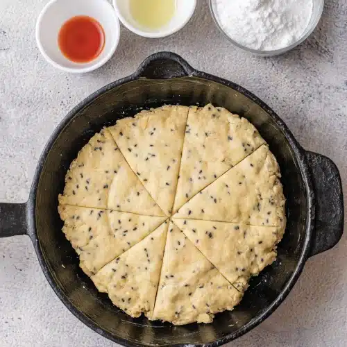 The dough round scored into eight wedges in the skillet
