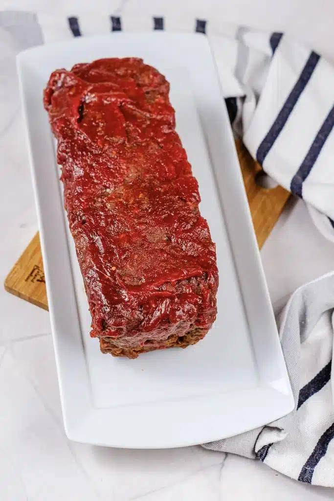 Lipton onion soup meatloaf glazed and whole on a white platter, seen from above