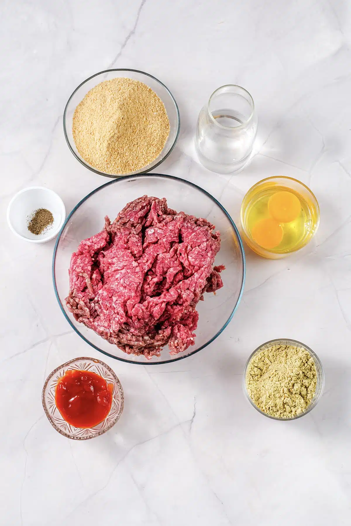Ingredients for Lipton onion soup meatloaf laid out in glass bowls on marble