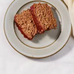 Two thick glazed slices plated on a speckled stoneware plate