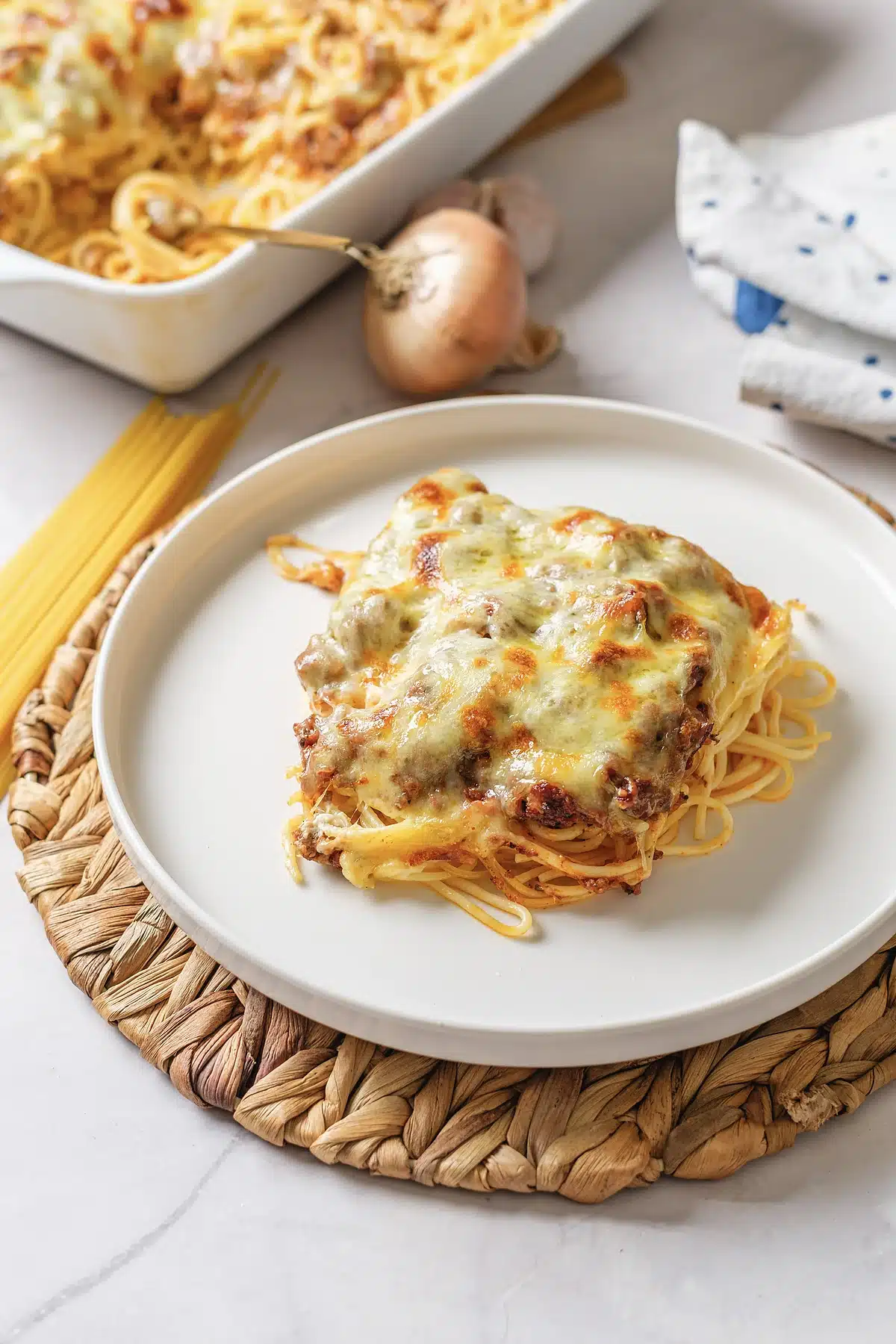 A single serving of million dollar spaghetti on a white plate