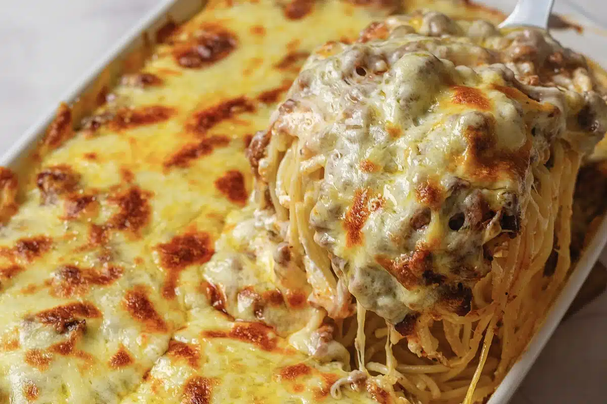 Melted cheese pulling away from a lifted forkful in the pan
