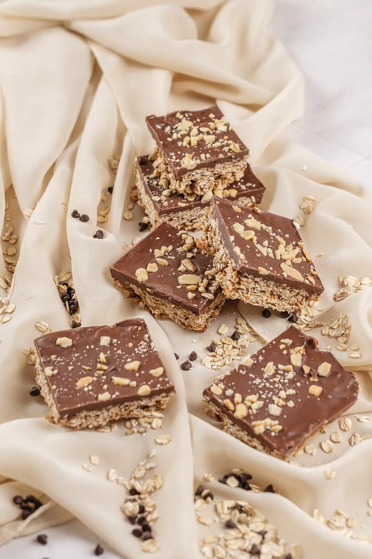 Oh Henry bars arranged on cream fabric with oats and chocolate chips scattered