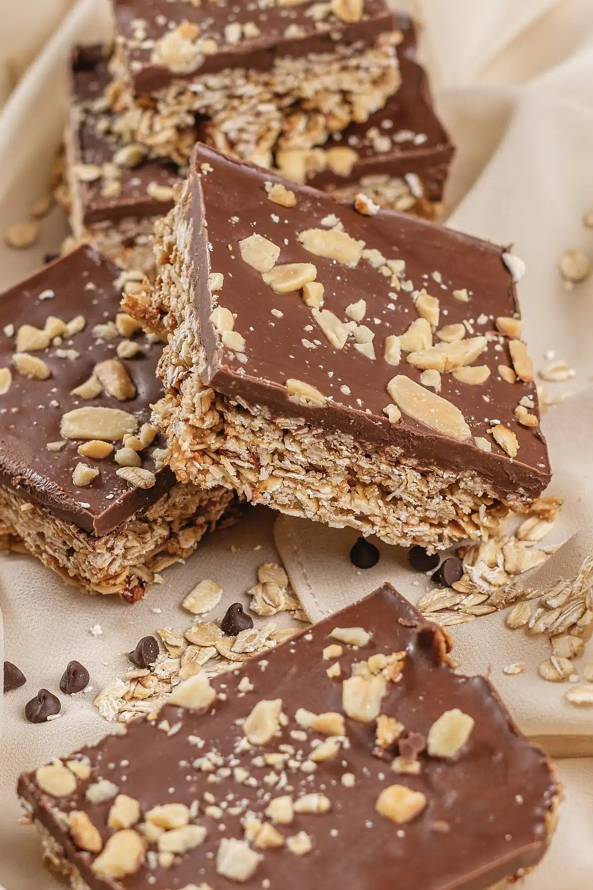 A close view of a chocolate topped square with chopped peanuts on top