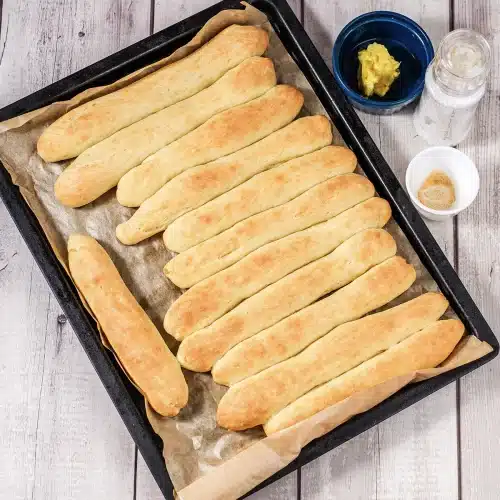 Baked ropes on a parchment-lined sheet with butter and salt alongside