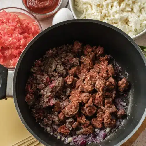 The beef and sausage browned and broken up in the pot