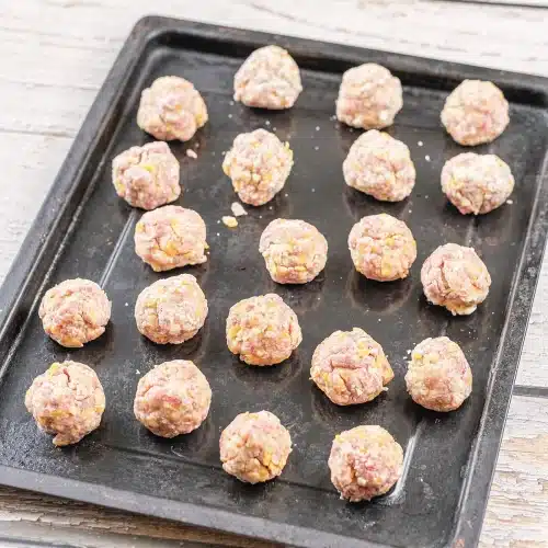 Raw rounds arranged in rows on a dark rimmed tray