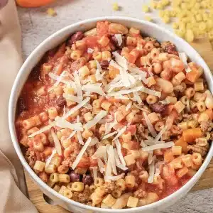 A single bowl of pasta fagioli topped with shredded parmesan