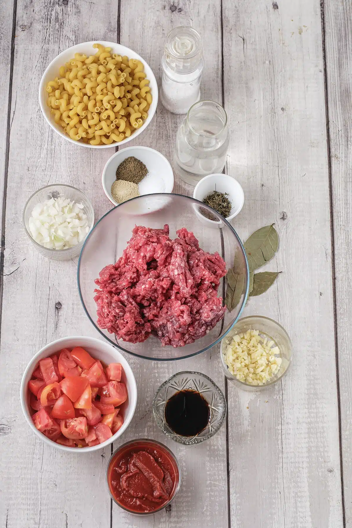 Ground beef, macaroni, tomatoes and seasonings laid out for American goulash