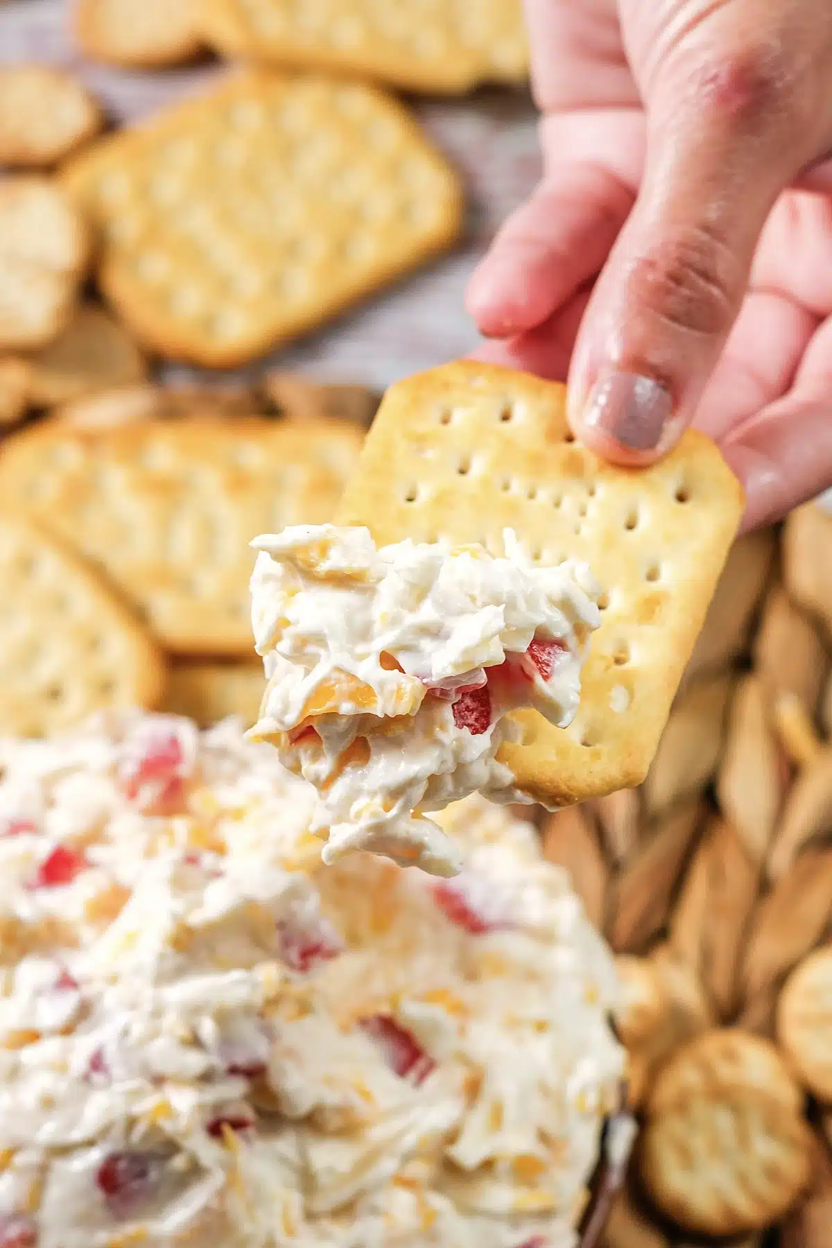 A cracker heaped with the creamy red-flecked mixture