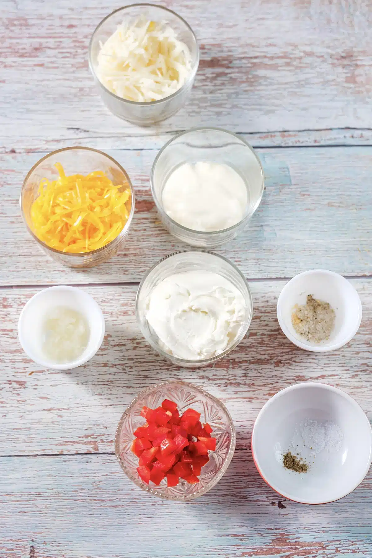 Cream cheese, mayonnaise, grated cheddar, diced pimentos and seasoning measured into glass bowls