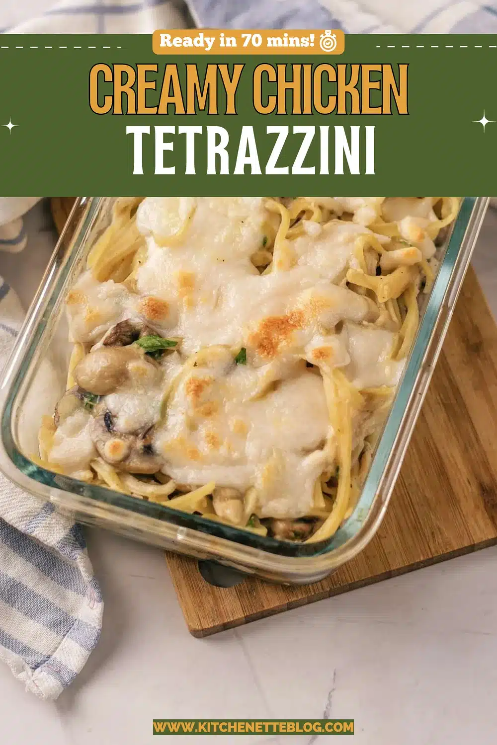 Baked linguine with mushrooms and browned mozzarella in a glass dish on a wooden board