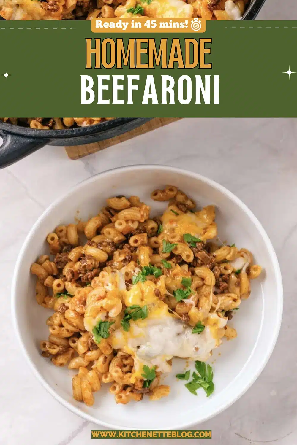 A white bowl of cheesy pasta with ground beef and parsley beside a black pot
