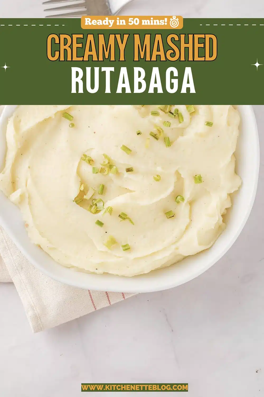 A white bowl of creamy pale puree with chives and a fork on a striped napkin