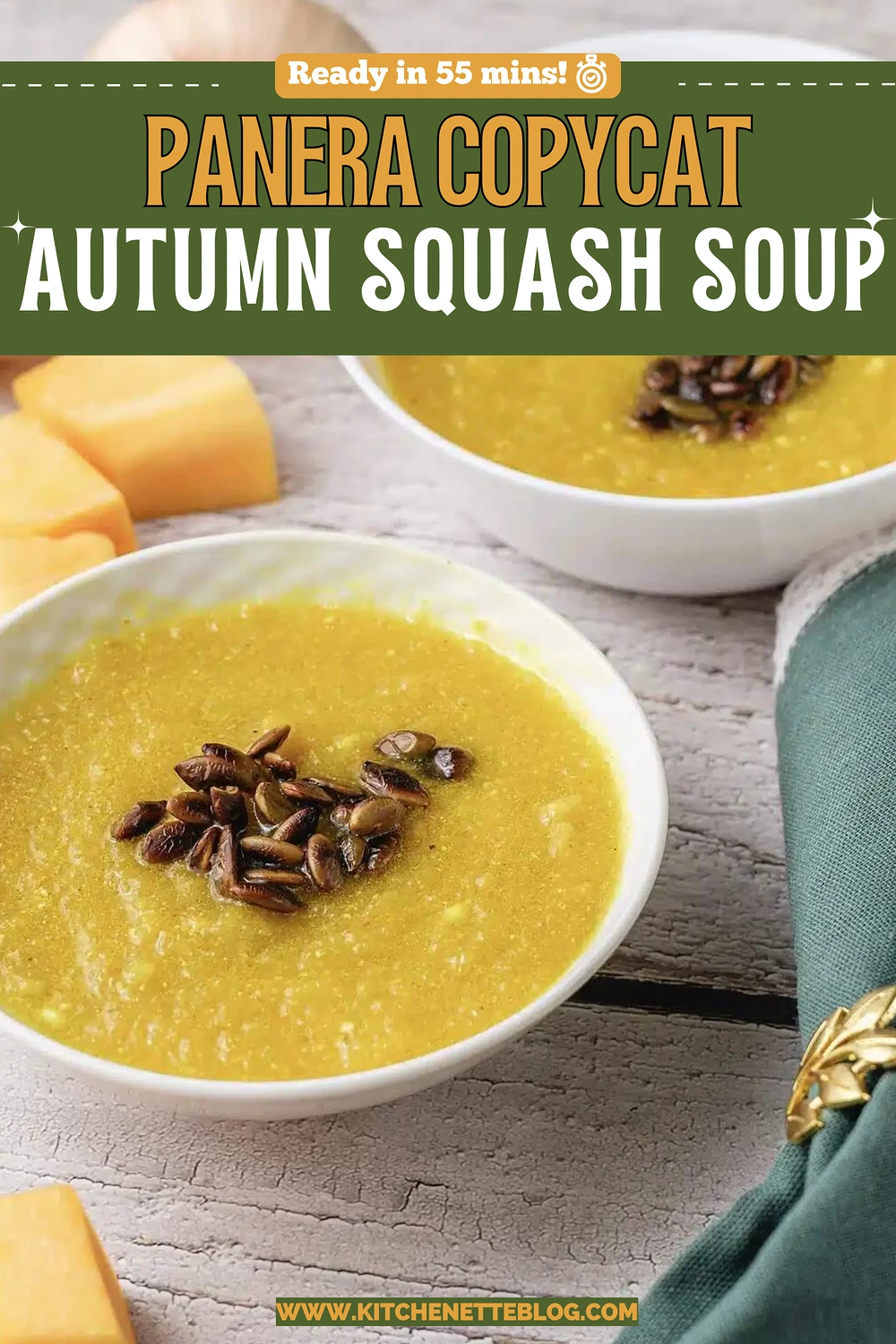 Two white bowls of golden puree topped with dark toasted seeds