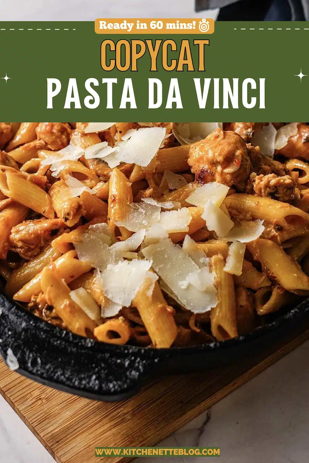 A cast iron skillet of penne in cream sauce topped with shaved cheese