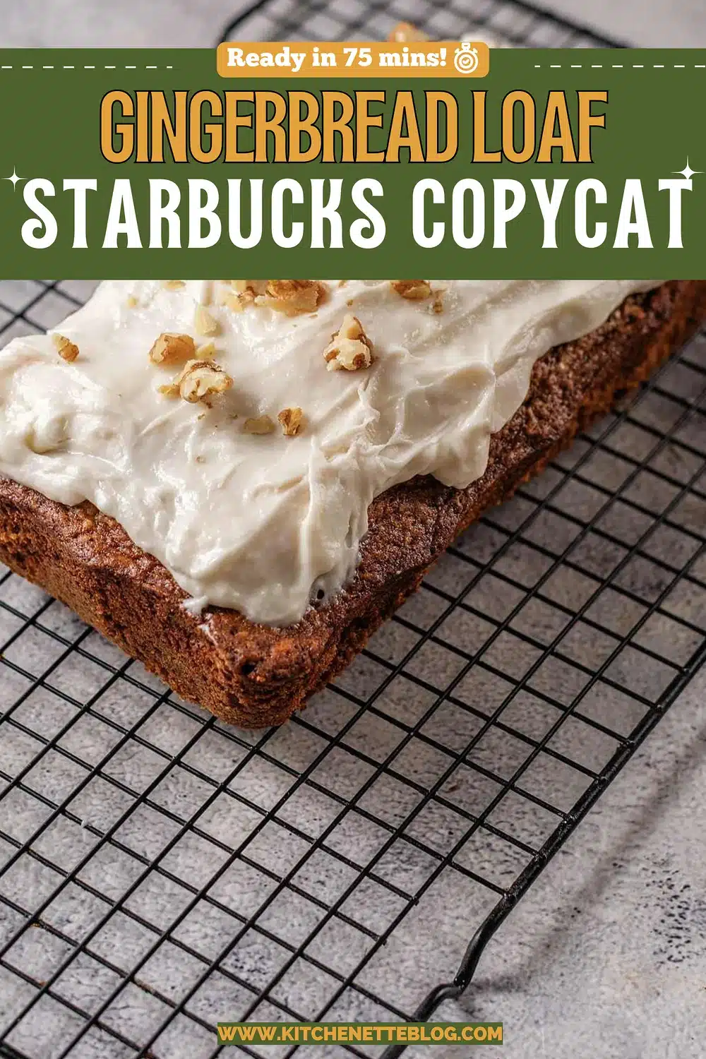 Frosted spice cake on a black wire rack topped with chopped walnuts