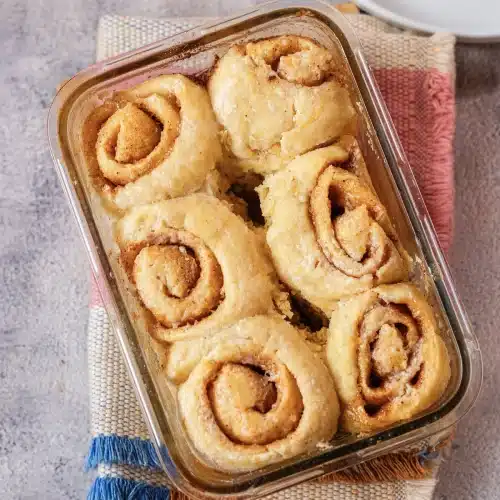 Six baked rolls golden brown in the glass dish