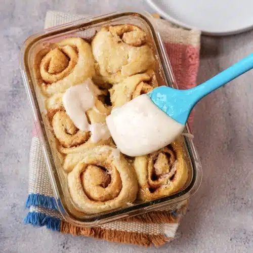 Cream cheese frosting spooned onto the warm rolls with a spatula