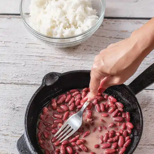 The pot filled and a fork stirring the contents together