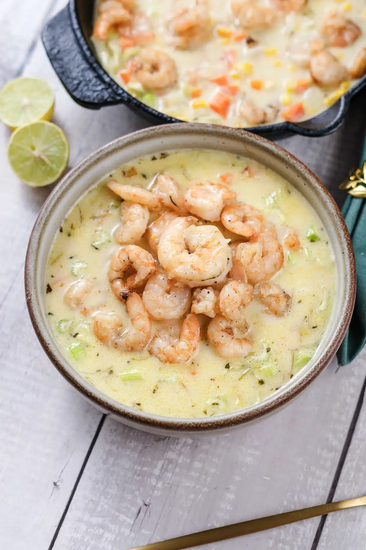 Shrimp chowder seen from above with a gold spoon resting alongside