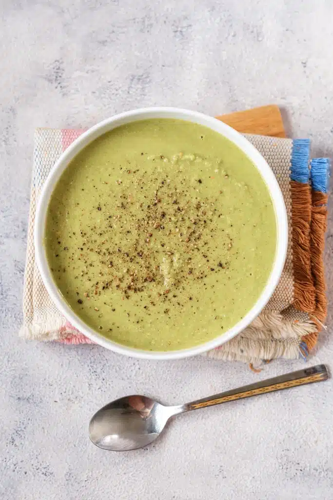 Split pea soup, quick green pea version, in a white bowl seen from directly above with a spoon below it
