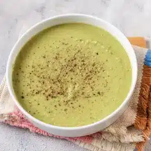 A single bowl of split pea soup, quick green pea version, on a striped napkin