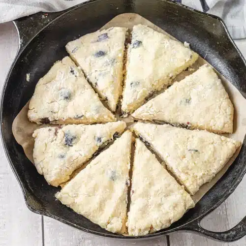 Raw dough patted into a cast iron skillet and cut into eight wedges