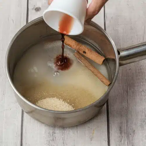Vanilla extract poured into the dissolved sugar syrup in the saucepan