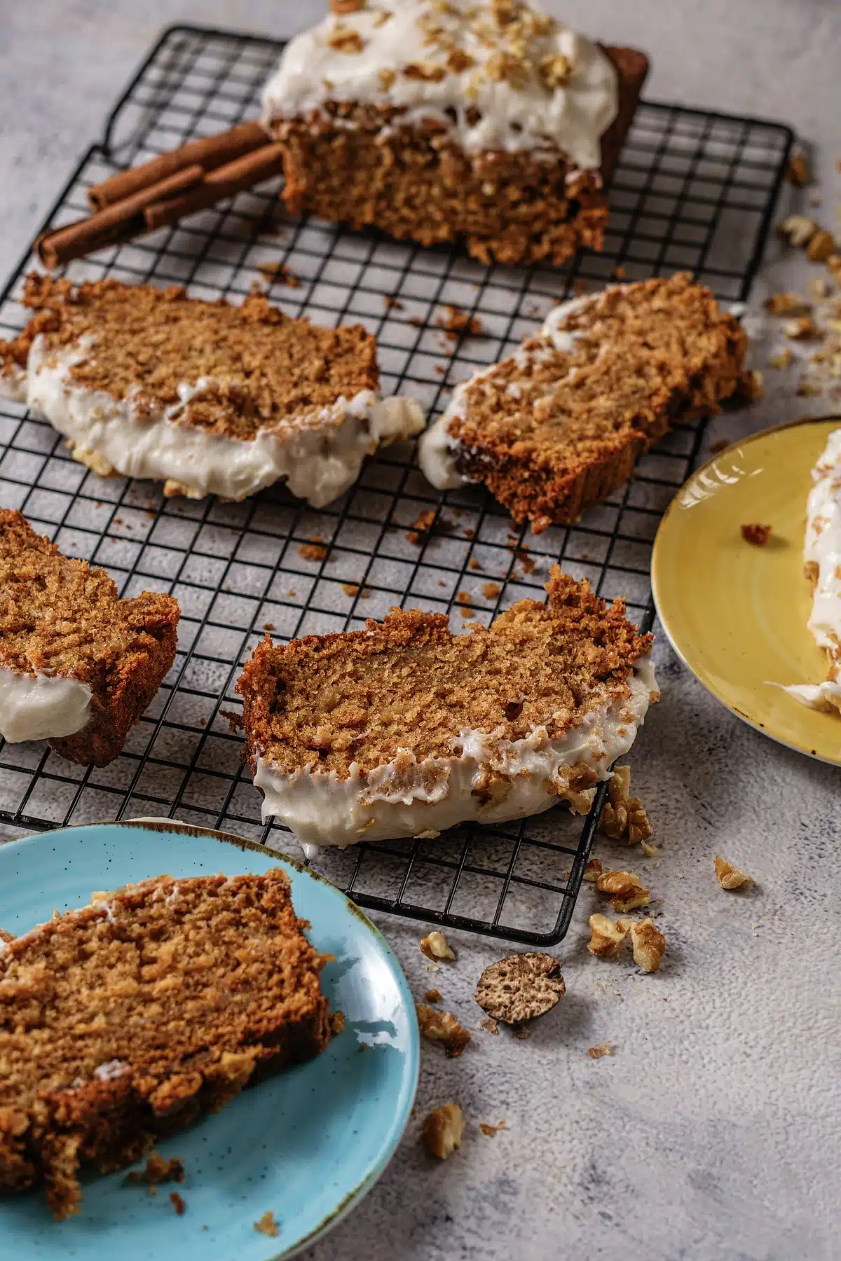 Slices of Starbucks gingerbread loaf on blue and yellow plates beside the cut cake