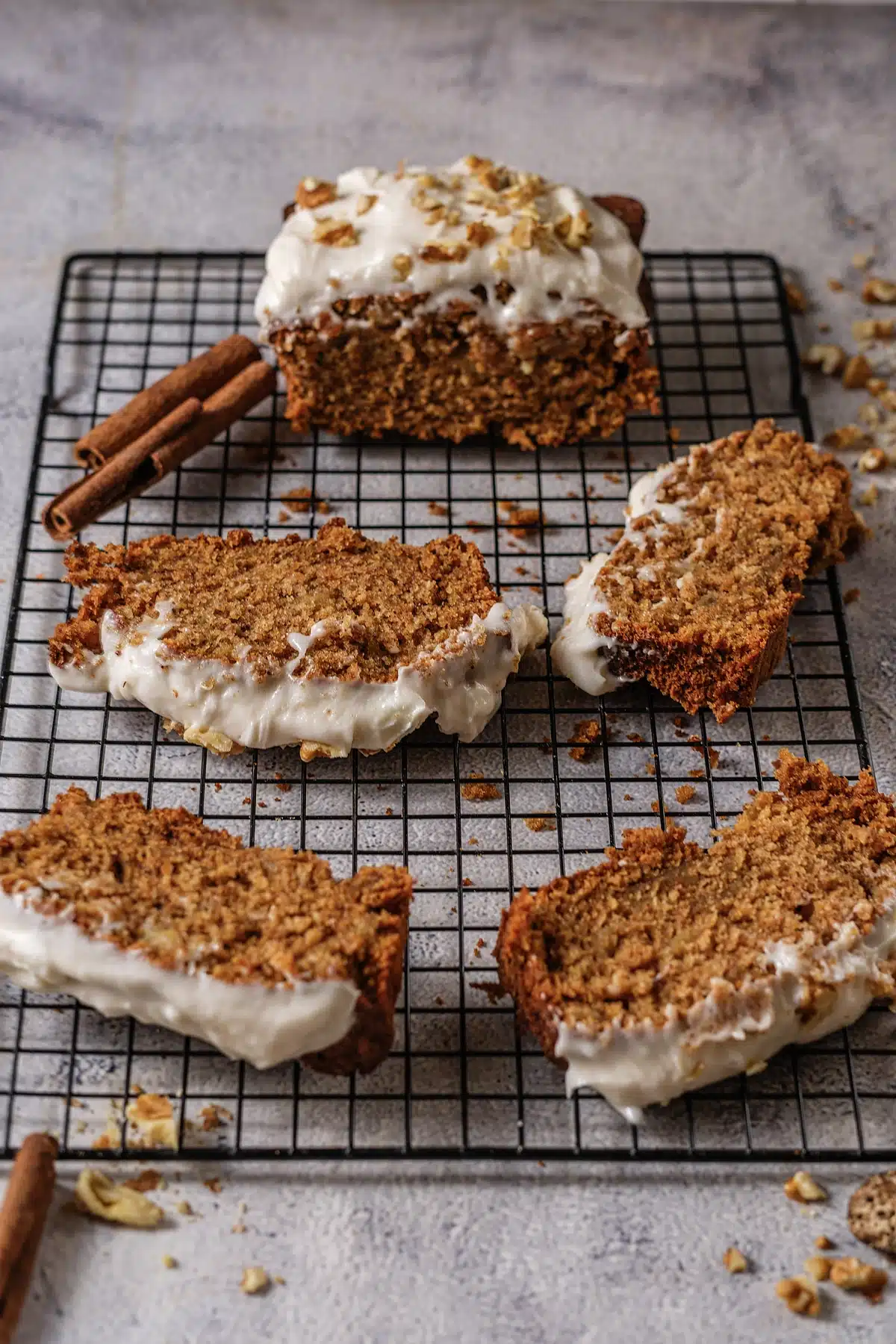 Thick frosted slices beside a cinnamon stick on a black wire rack