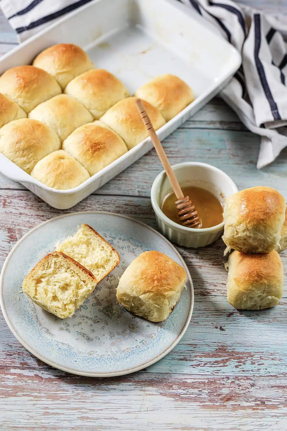 A pan of golden pull-apart squares with a striped towel folded behind it