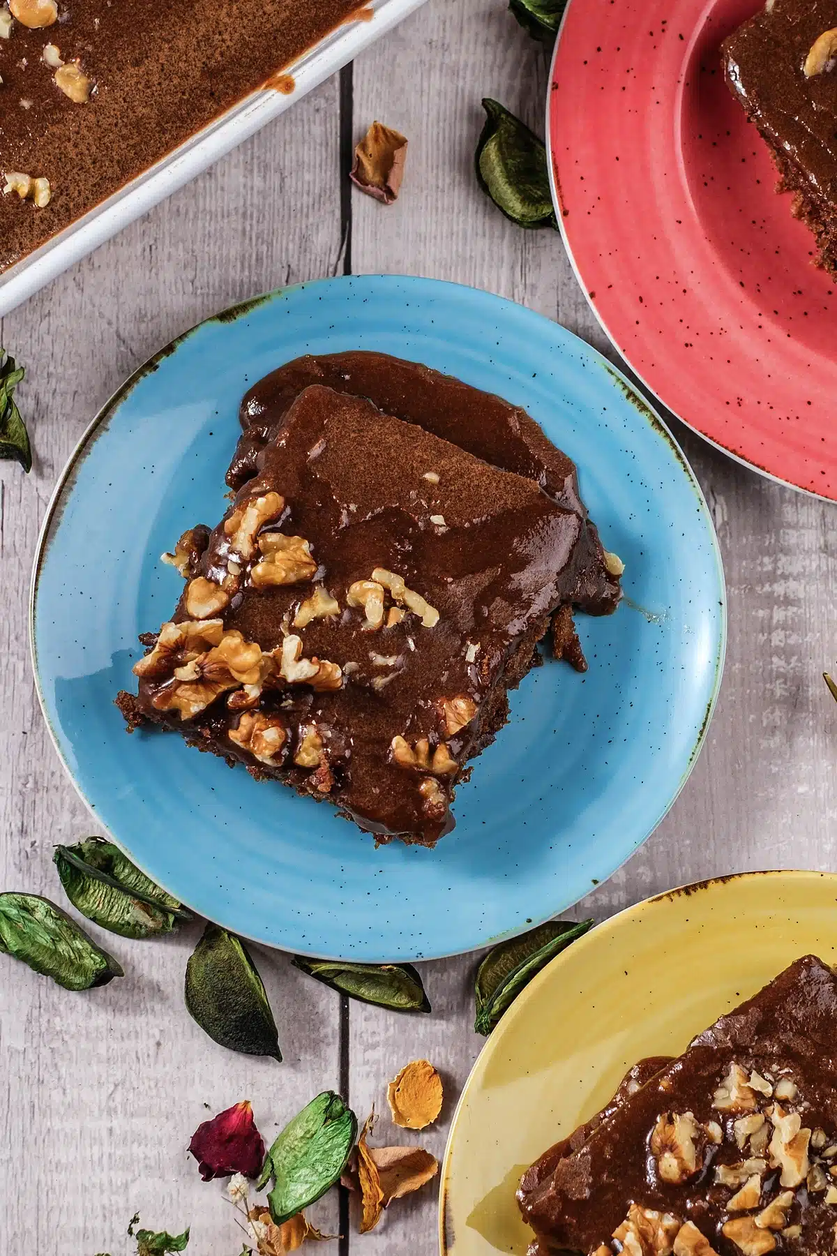 Texas sheet cake on a blue plate with walnuts, seen from above
