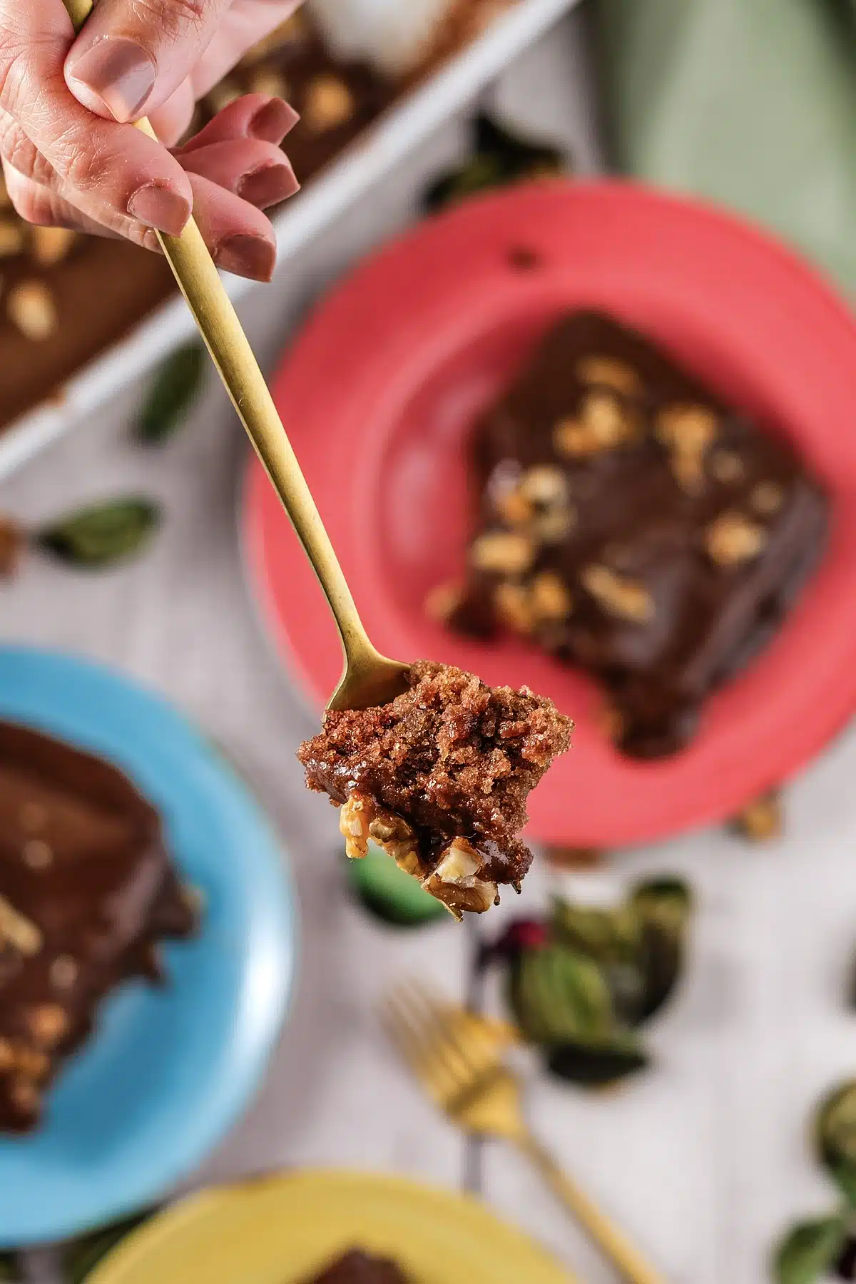 A forkful lifted from a nut-topped square on a red plate