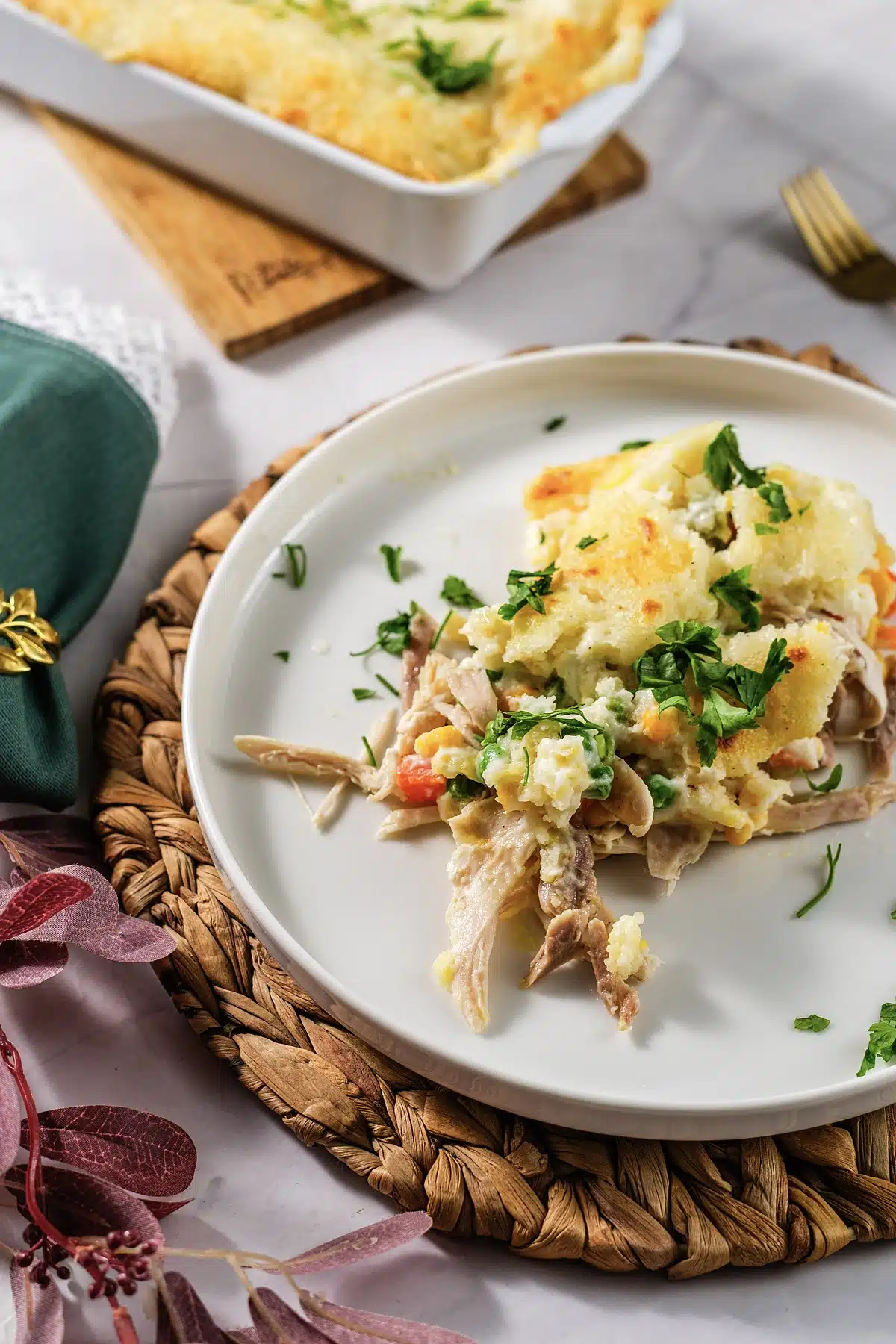 Chicken cobbler on a plate with the golden topping and chopped parsley