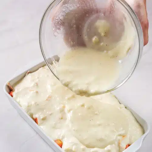 The broth and soup mixture poured slowly over the spread batter