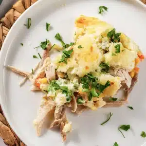 One plated scoop of the creamy bake with its soft golden topping and parsley