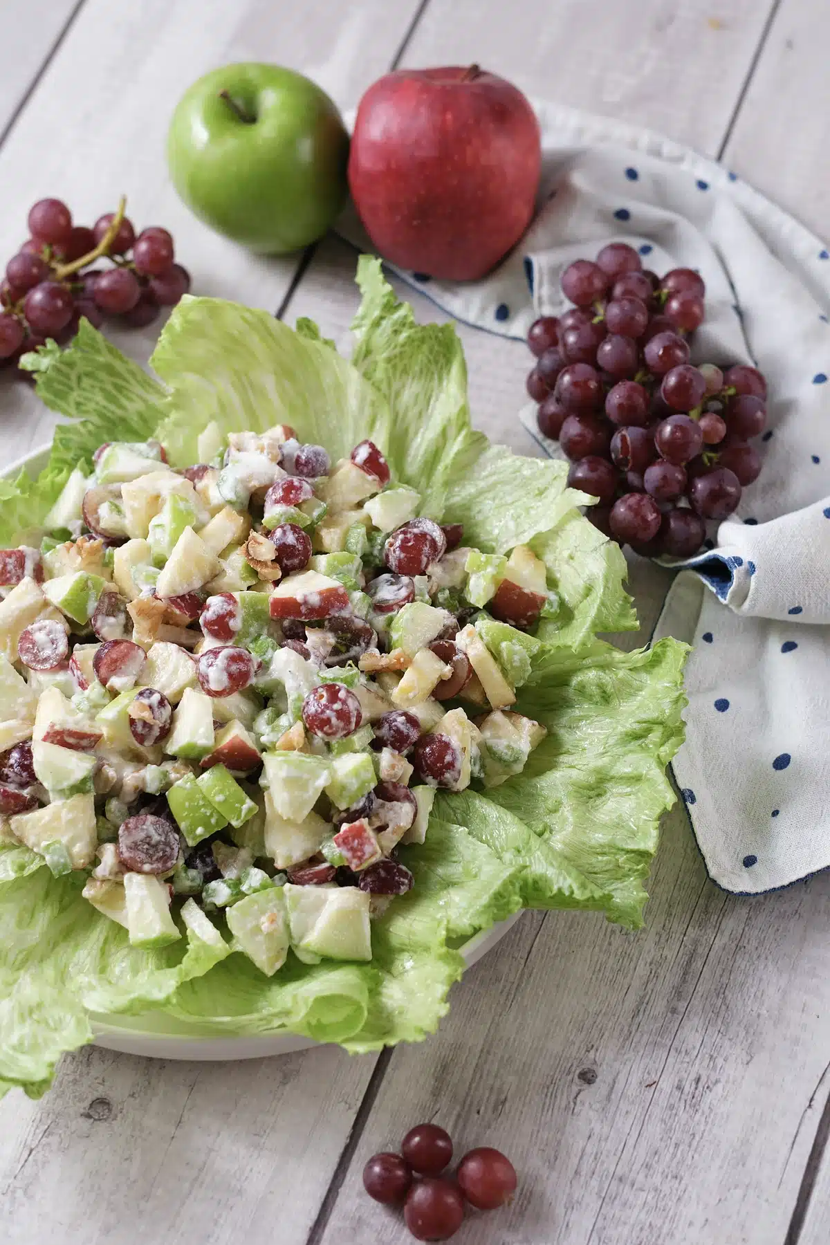 Waldorf salad served on iceberg leaves with a blue and white napkin