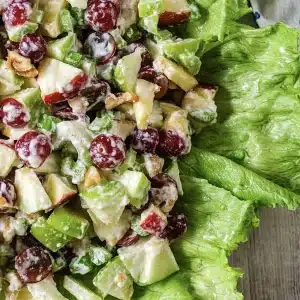A single portion of chopped apple, grape and celery heaped on a lettuce leaf