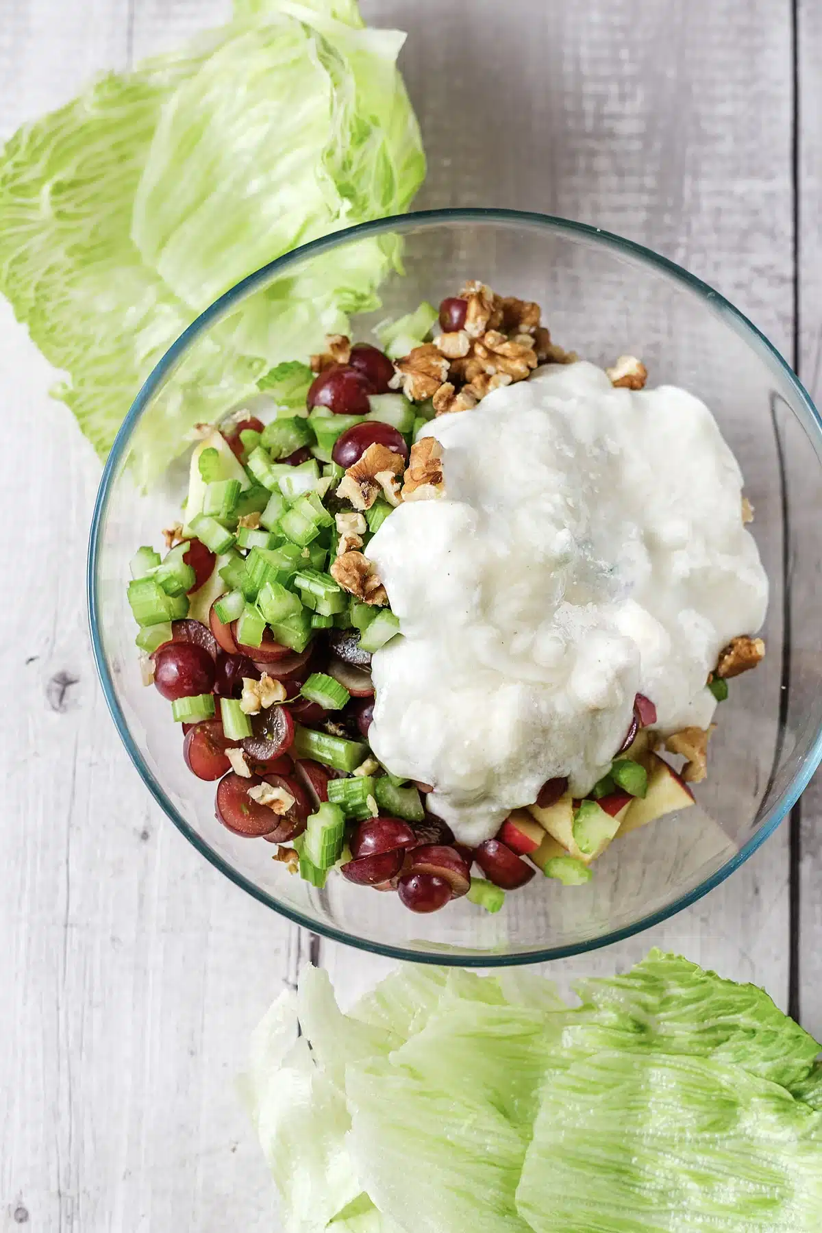 The pale dressing sitting on top of the chopped fruit before it is folded through