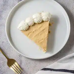 A single slice of peanut butter pie with a piped whipped topping border on a white plate